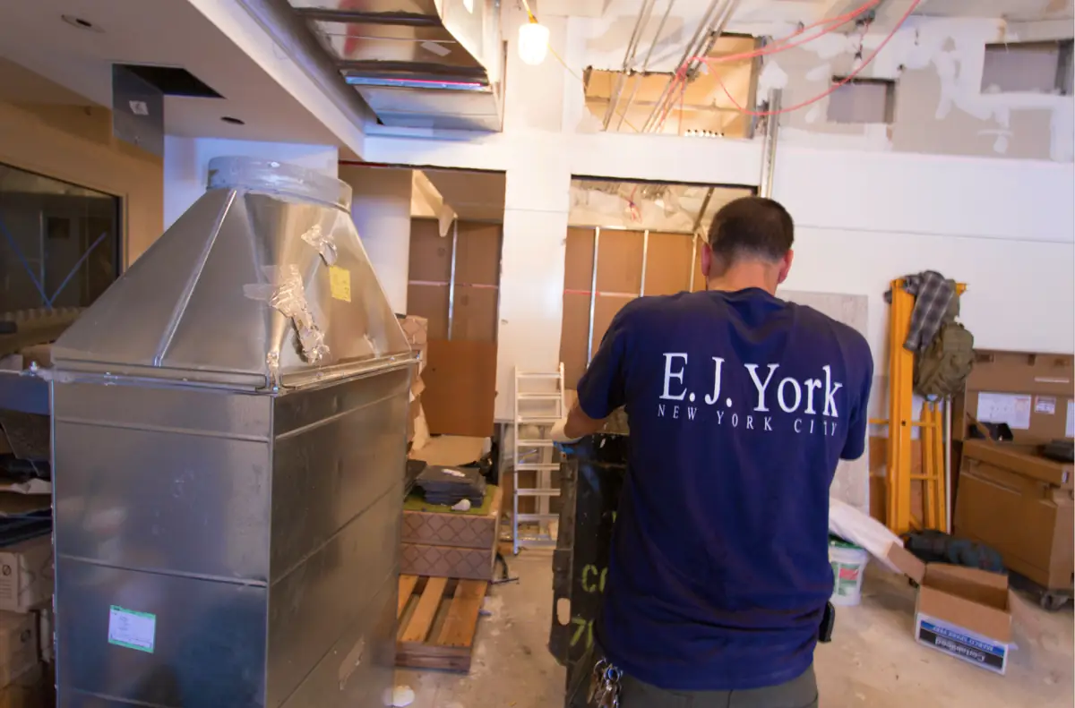 An E.J. York crew member fitting ductwork on a New York job site
