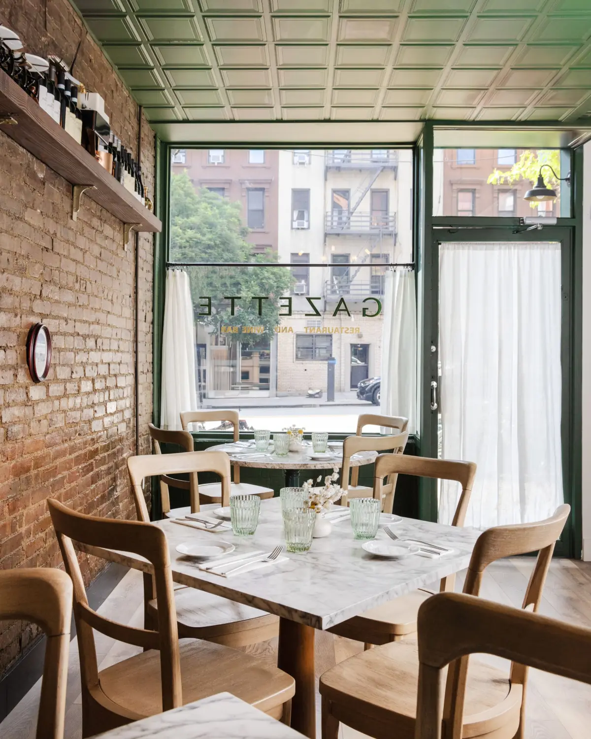 Gazette dining room with brick wall and bistro chairs