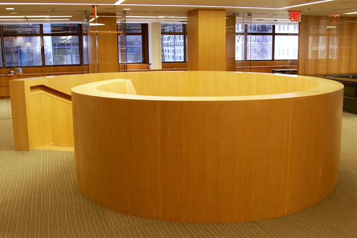 Round reception desk clad in Anigre wood