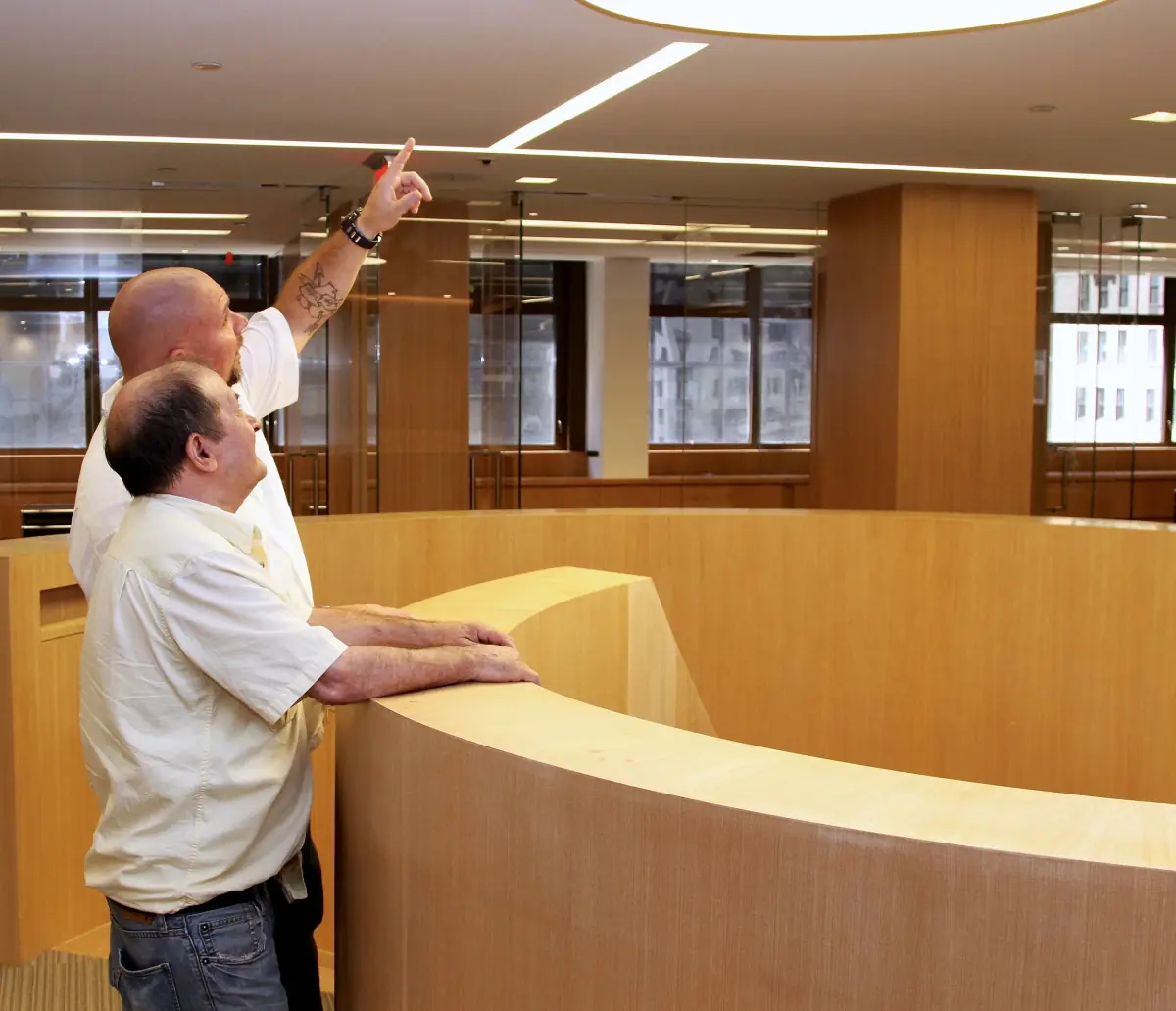 Two E.J. York project leads reviewing ceiling details at the Park Avenue offices