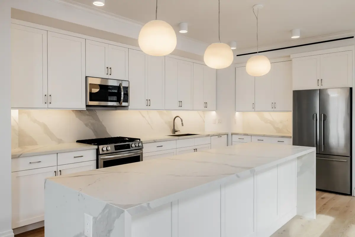White kitchen with a marble waterfall island