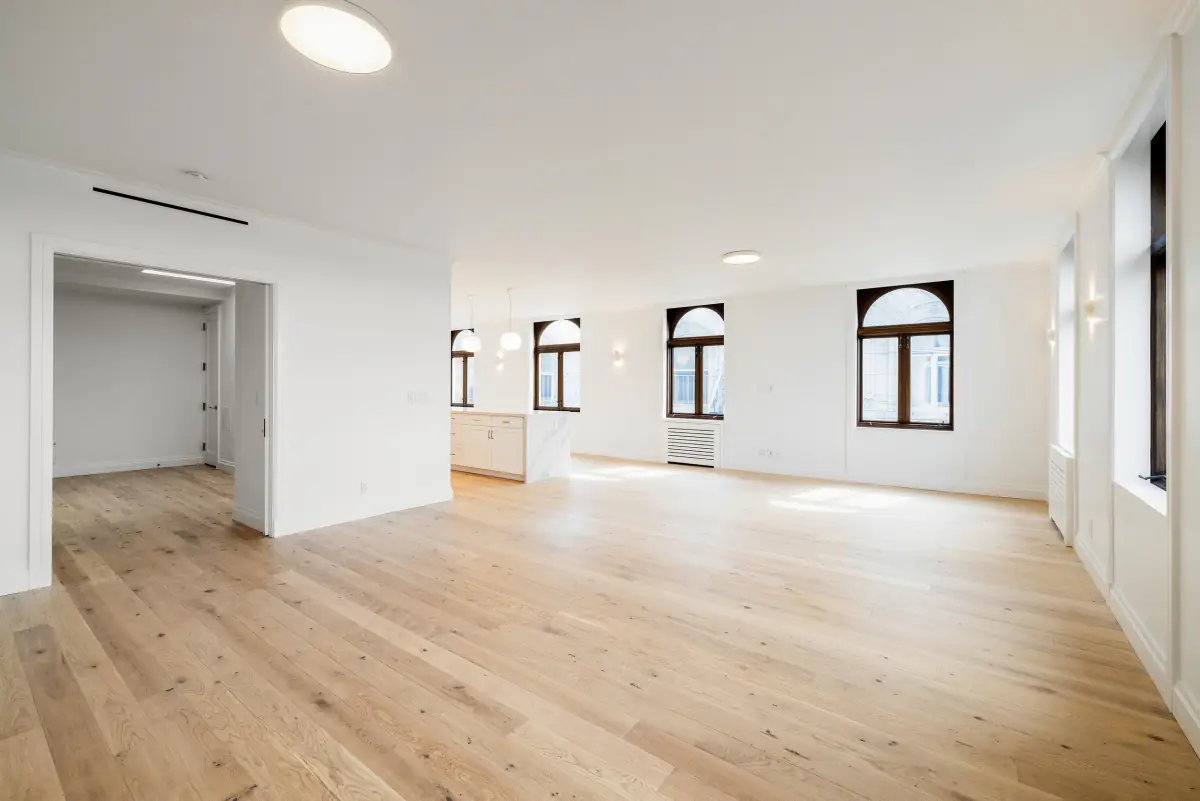 Open living room with oak floors and arched windows